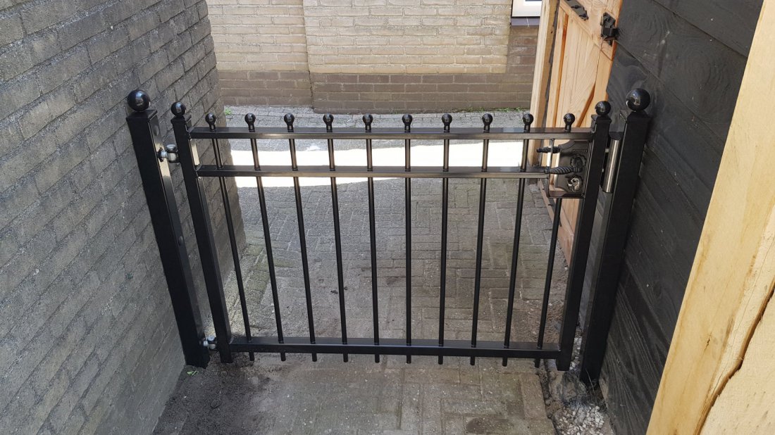 Stalen poort in een tuin die goed onderhouden is