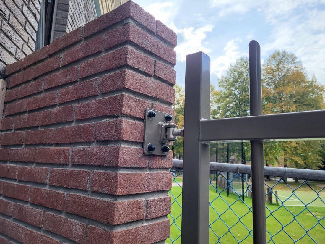 Bevestiging van een stalen poort aan de muur