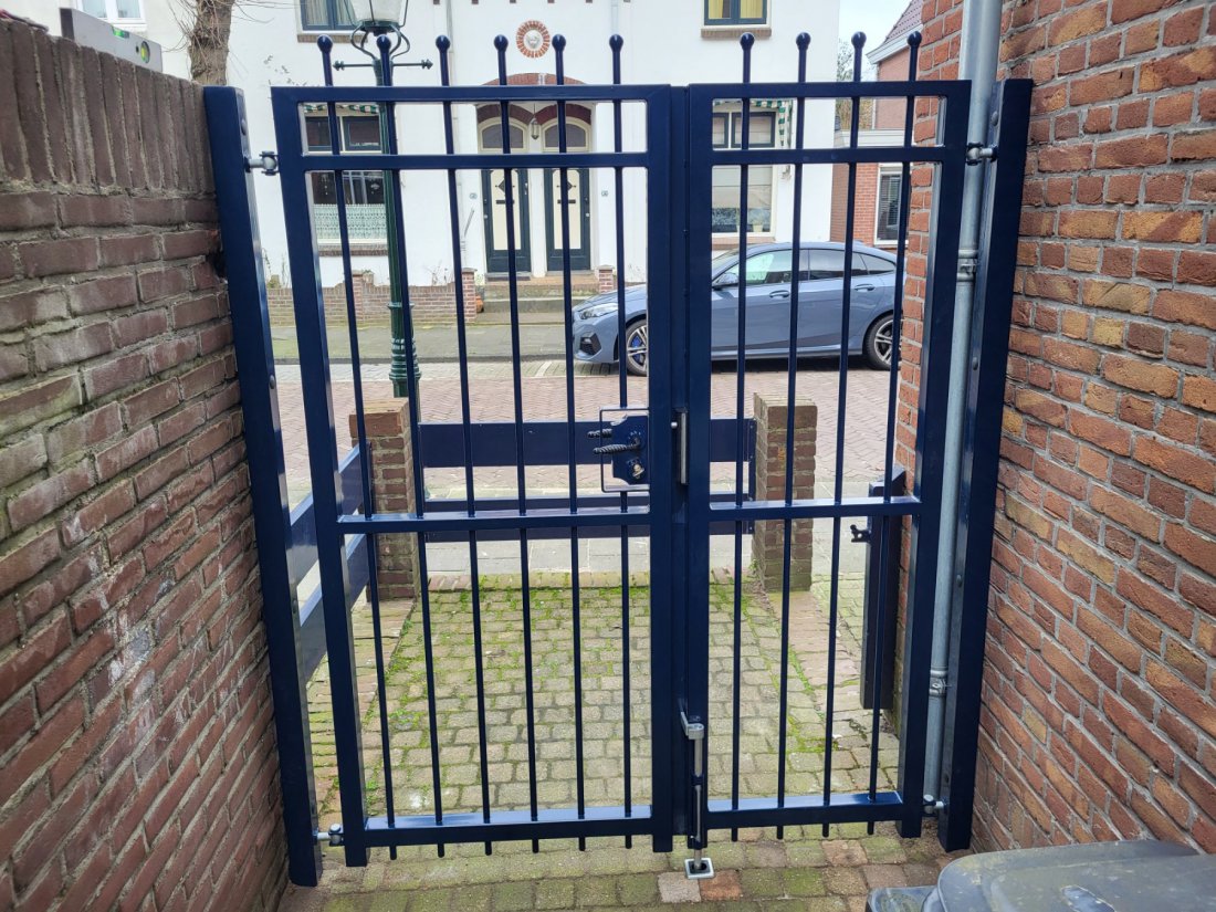 Blauwe stalen looppoort met spijlen