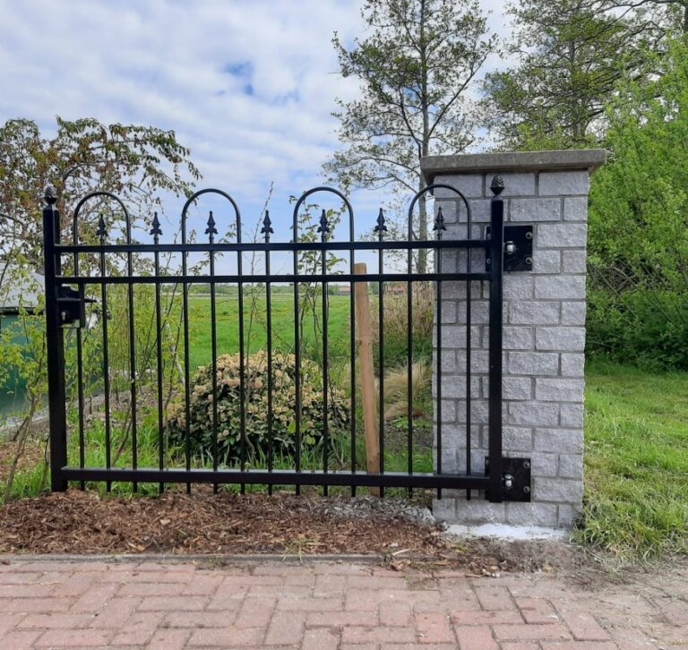 Draaipoort op stenen poeren, windbestendig geplaatst in het open Friese landschap
