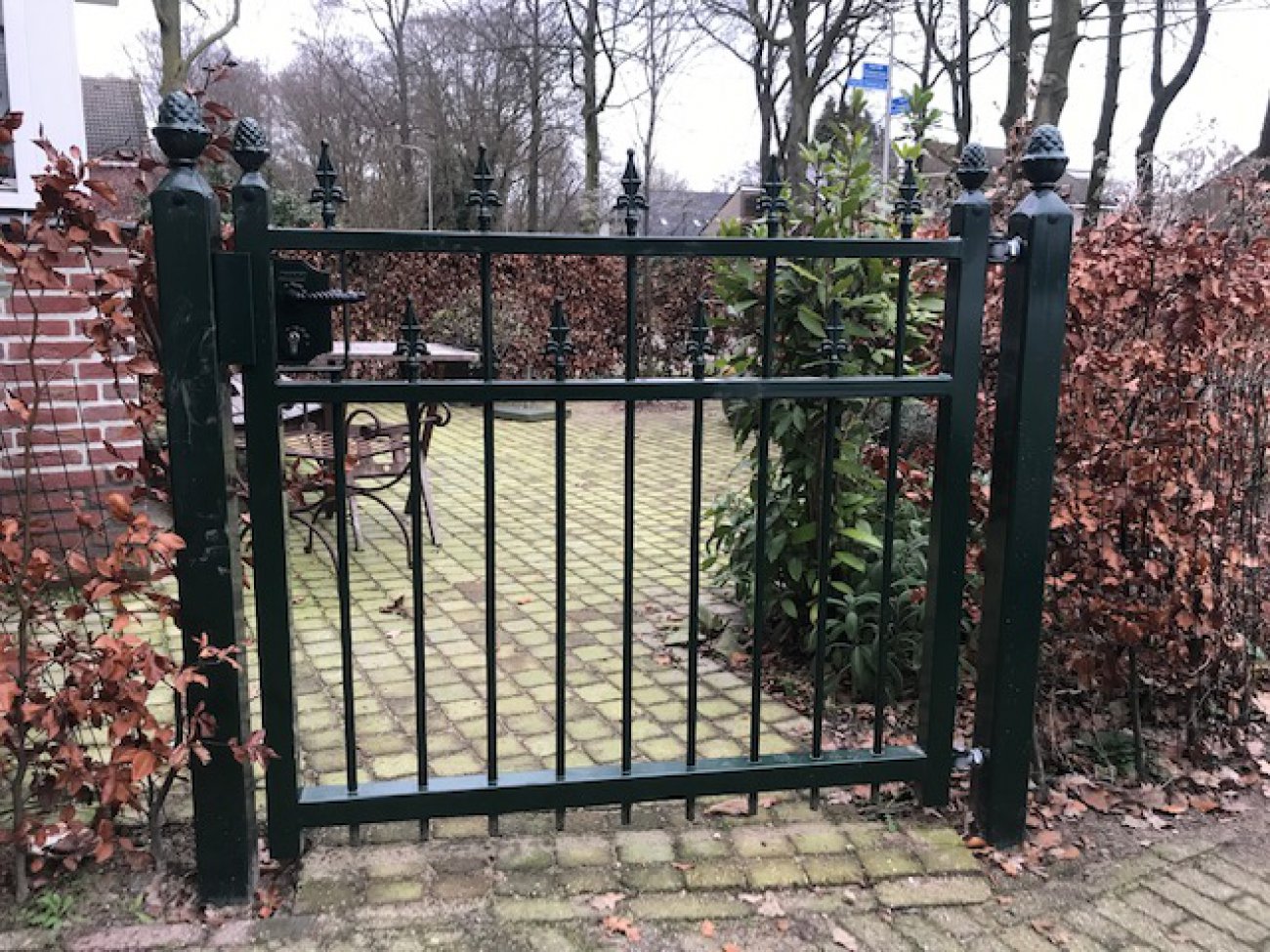 Groene looppoort bij een woning aan het water