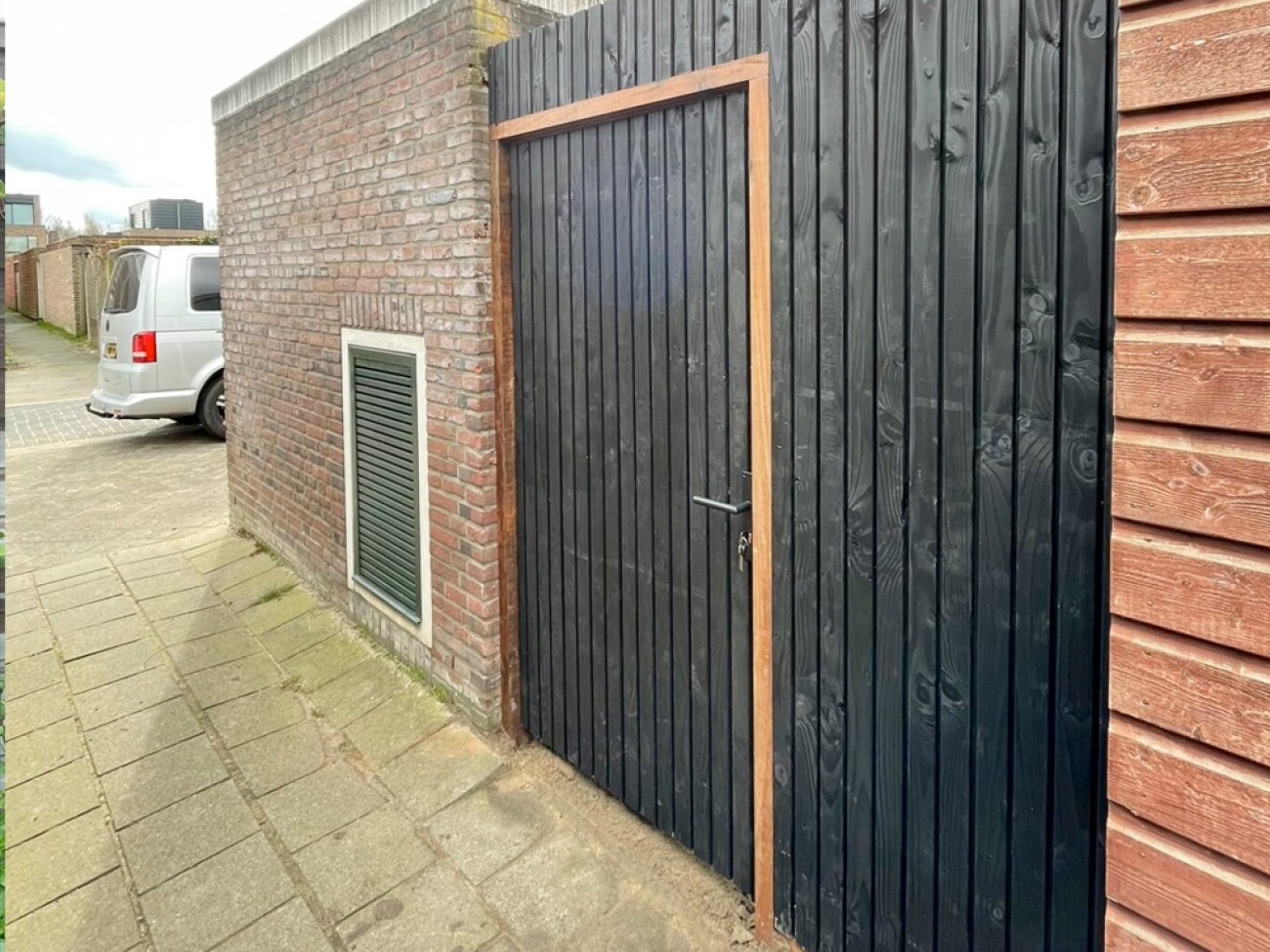 Houten poort in Deens rabat, zwart verticaal, bij een woning in Súdwest-Fryslân