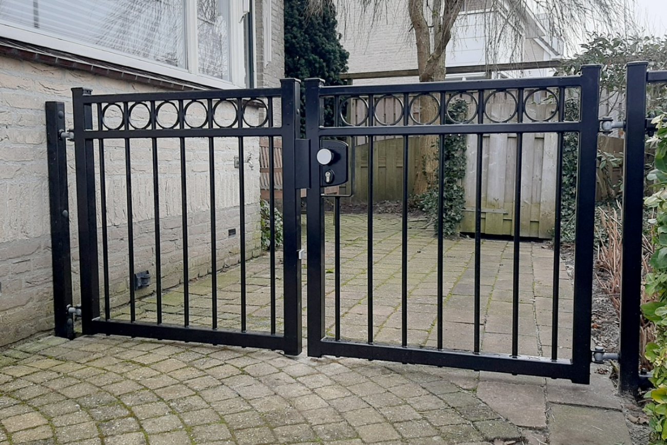 Zwarte looppoort naast de oprit bij een huis in Sneek
